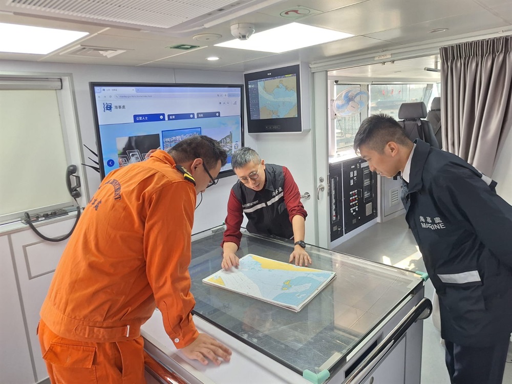 梁先生（右二）在巡邏船上與前線同事商討工作